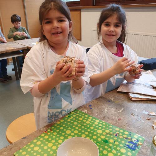 Kinder arbeiten mit Pappmaché