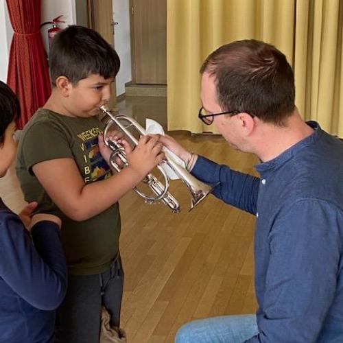 Trompetenlehrer mit einem Jungen, der probiert