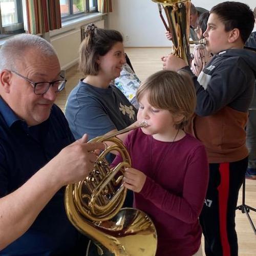 Lehrer und Kinder an den Instrumenten