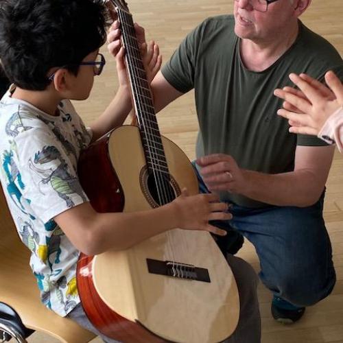 Der Gitarrelehrer mit einem Kind