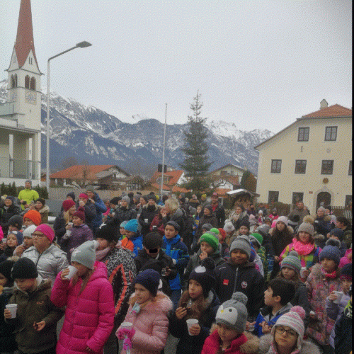 alle Kinder stehen vor der Schule - im Hintergrund sieht man die Kirche