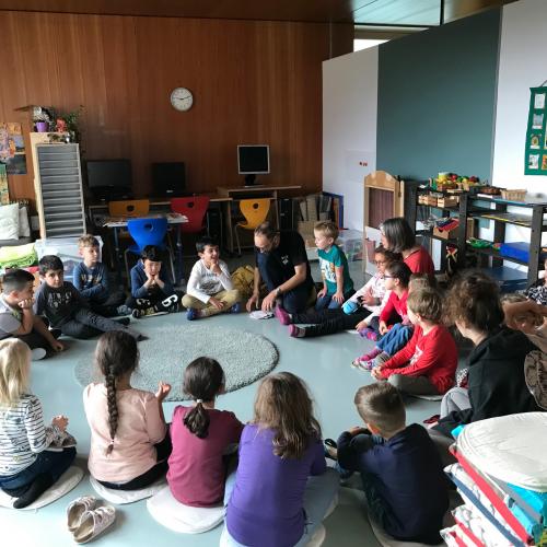 Kinder sitzen im Kreis