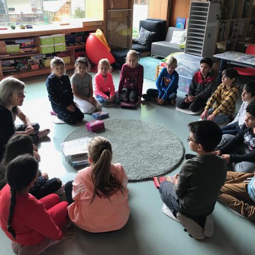 Kinder sitzen im Kreis