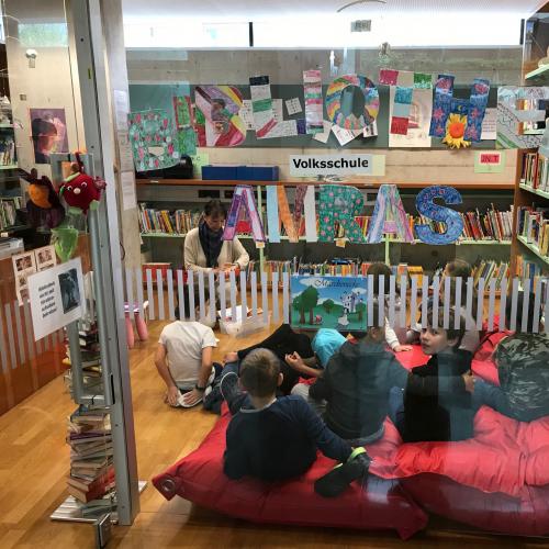 Kinder sitzen in der Bibliothek