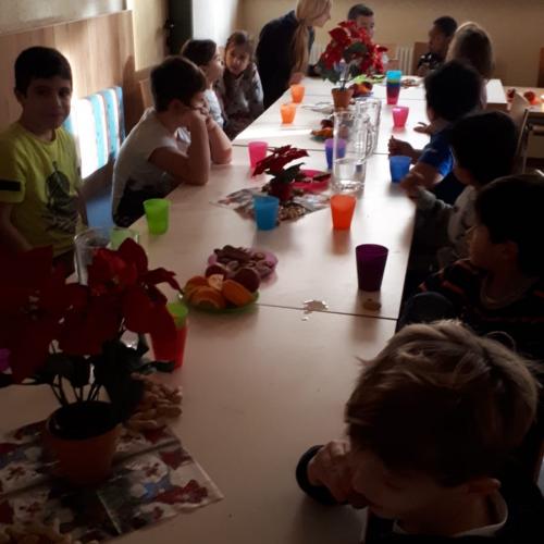 Kinder sitzen bei Keksen und Saft