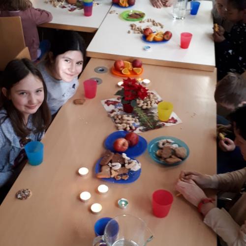 Kinder sitzen bei Keksen und Saft