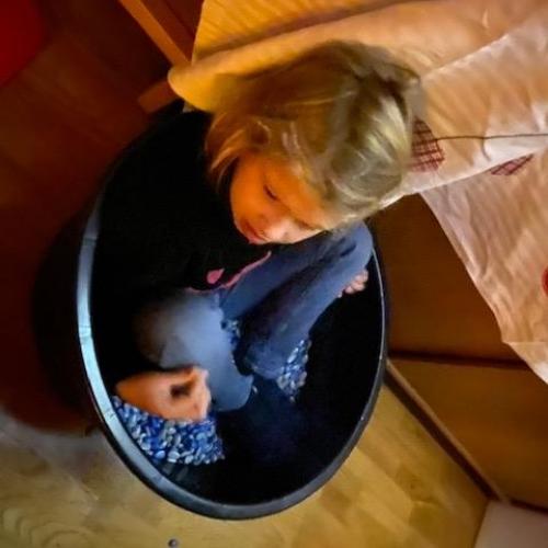 Kind sitzt im Bohnenbad