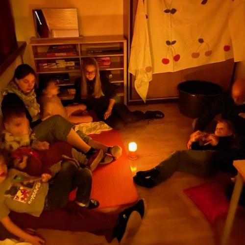 Kinder und Betreuer am Boden sitzend