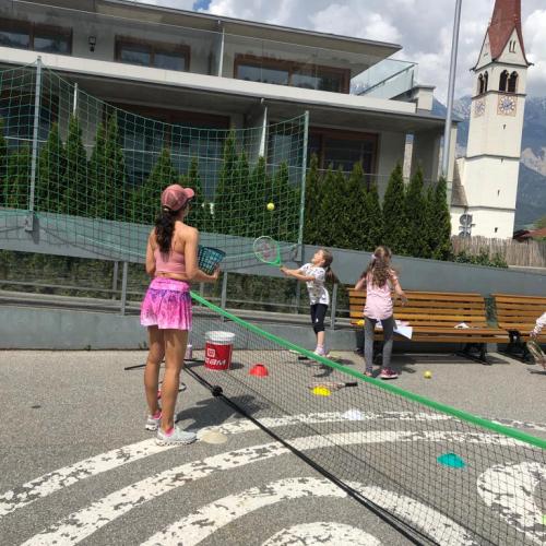 Tennislehrerin und Kinder im Hof