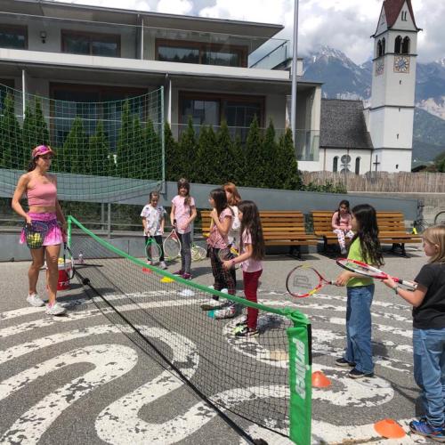 die Kinder stehen im Hof mit der Tennistrainerin