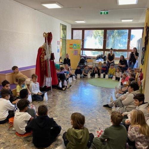 Nikolaus-Besuch bei den dritten Klassen - Kinder sitzen im Sitzkreis
