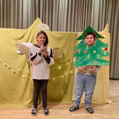 2 Kinder aus der 1a - Mädchen mit Heiligenschein und Flügeln und Junge als Christbaum verkleidet