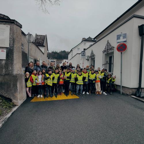 Kinder in gelben Warnjacken stehen auf dem Kirchsteig zwischen den Schildern Schulstraße und Sackgasse