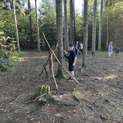 Kinder bauen ein Tipi im Wald