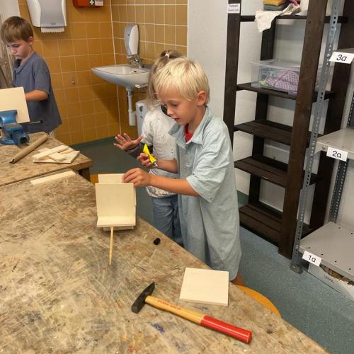 Blonder Junge beim arbeiten mit Holz