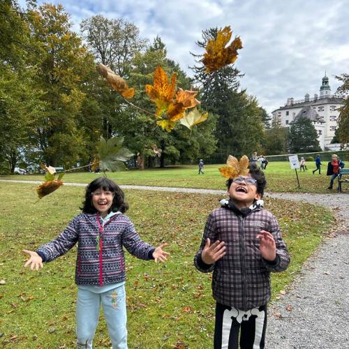 Kinder werfen Blätter in die Luft
