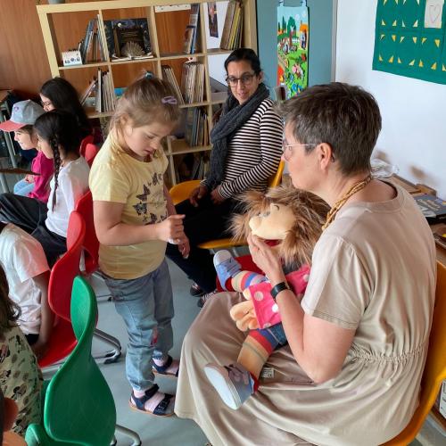 Fr. Direktor hat die Handpuppe Iselotte Keksberg am Schoß