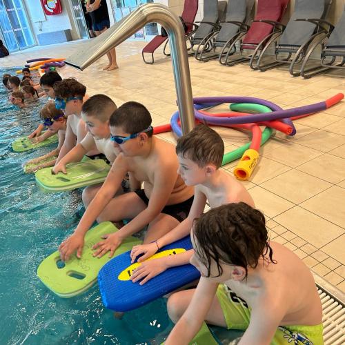Kinder sitzen am Beckenrand
