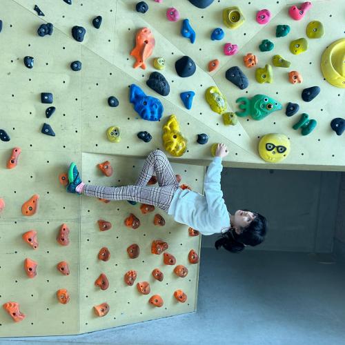 Kind klettern in der Boulderhalle 