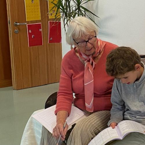 Leseoma liest  mit Kind auf dem Sofa