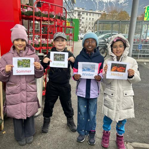 Kinder mit Jahrezeitenschilder