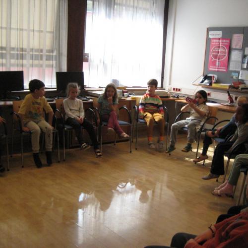 Kinder sitzen im Stuhlkreis im Konferenzzimmer