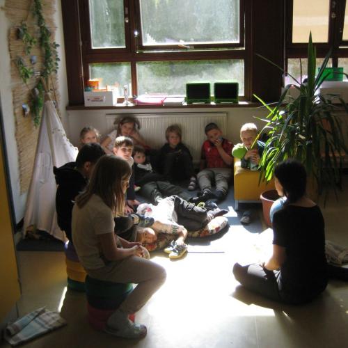 In der Leseecke sitzten mehrere Kinder - im Vordergrund liest die L