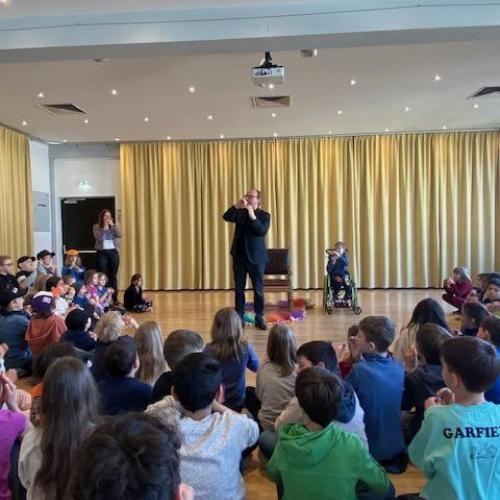 Der Bischof singt mit den Kinder ein Lied mit Handzeichen