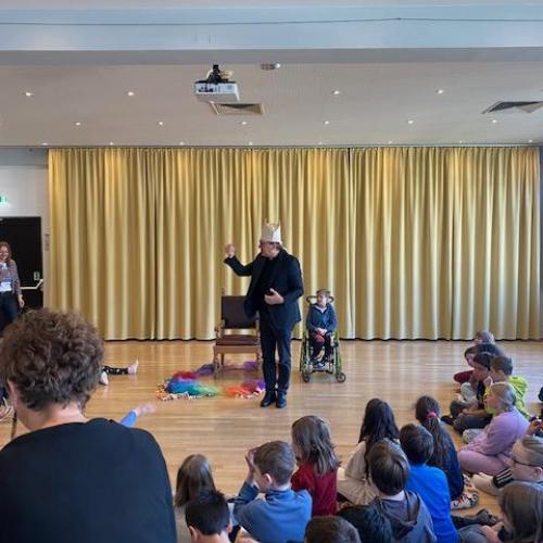 Der Bischof mit Mütze spricht vor den Kindern