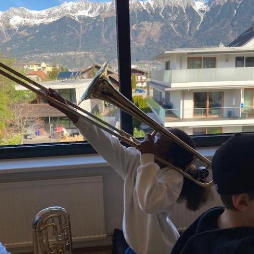 Ein Mädchen spielt die Posaune und zieht nach oben