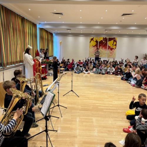 Blick in den Gemeindesaal mit Kinder-Publikum, Bläserkindern und Nikolo und Engel