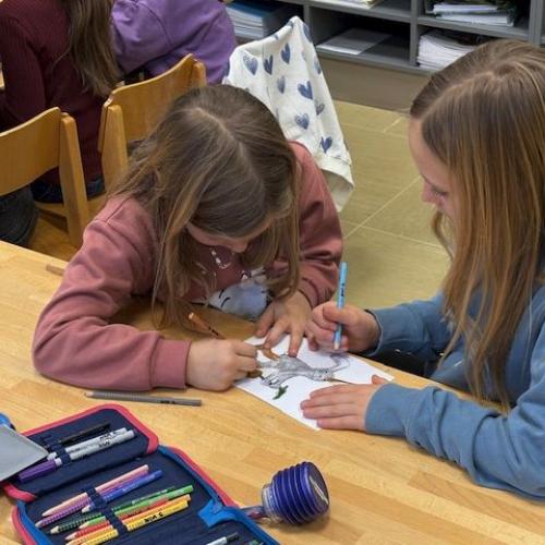 2 Kinder arbeiten zusammen an einem Blatt