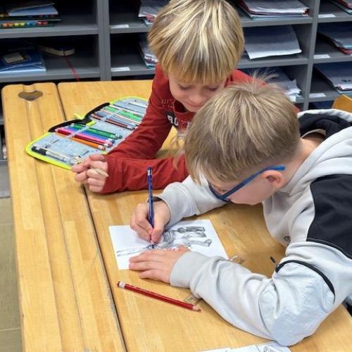 Ein Kind der 4. arbeitet mit einem der 1.