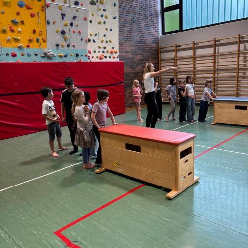 Die Kinder stehen in Schlangen hinter den Kästen, um sie, wie einen Bob zu schieben