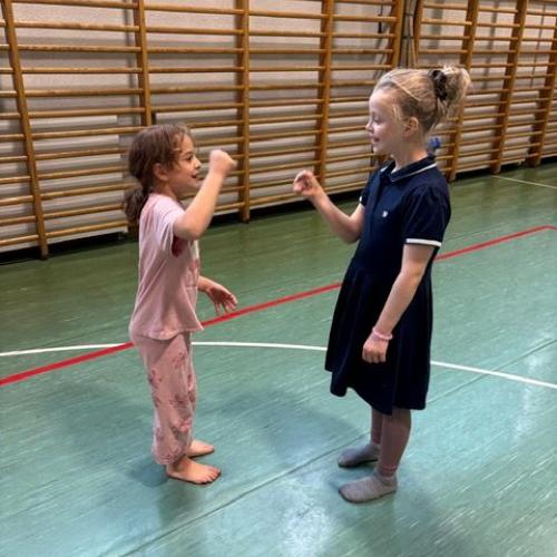 2 Mädchen bei einem Hand-Spiel im Turnsaal