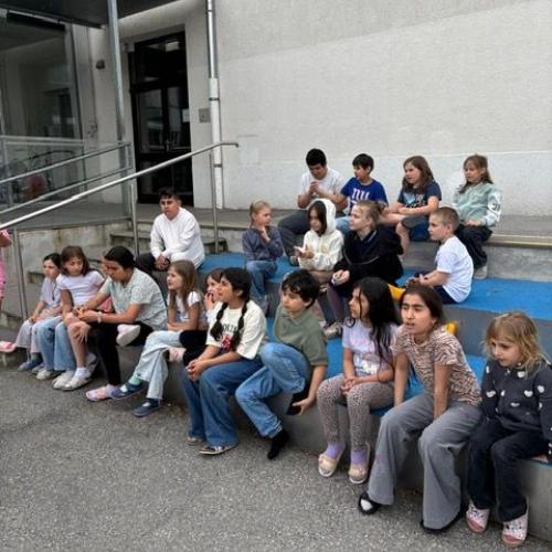 eine Gruppe von Kindern sitzt draußen auf der Treppe