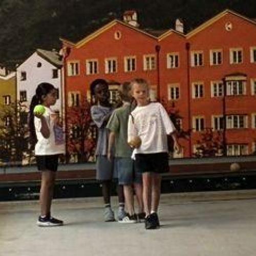 Kinder stehen an, um zu werfen. Im Hintergrund sieht man Anbruggen als Bild
