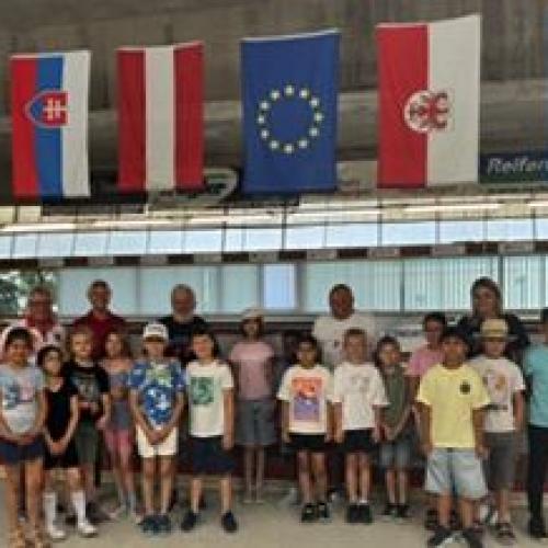 Gruppe steht in der Bocciahalle unter den Fahnen