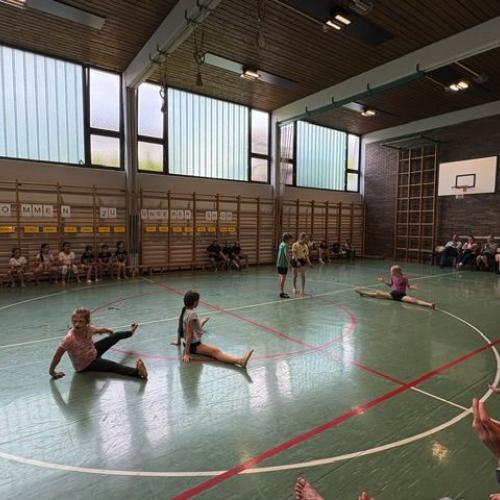 3 Kinder sitzen mit einer Grätsche am Boden