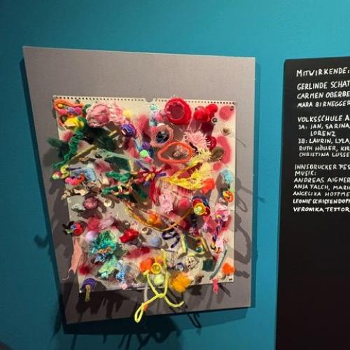 Die Skulptur unserer Schüler aus verschiedensten Materialien als ein Kunstwerk an der Wand mit Namen der Schöpfer