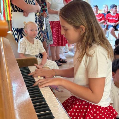 Das Mädchen mit rotem Rock spielt Klavier