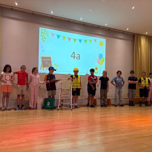 Die Kinder der 4a stehen aufgereiht nebeneinander auf der Bühne