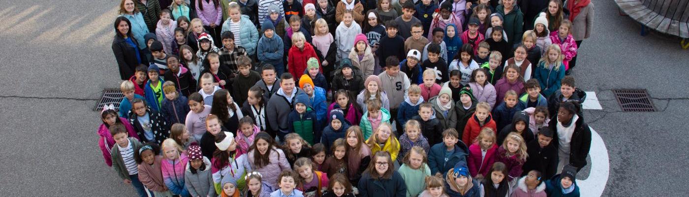 Foto von oben auf alle Kinder und Erwachsenen. Sie stehen auf dem Labyrinth