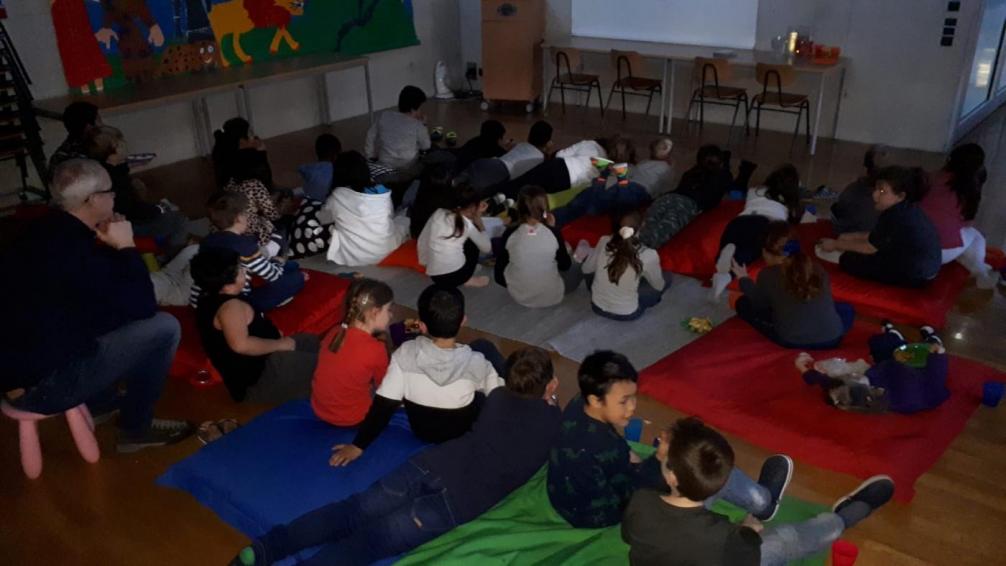 Kinder sitzen vor der Kinoleinwand im Medienraum