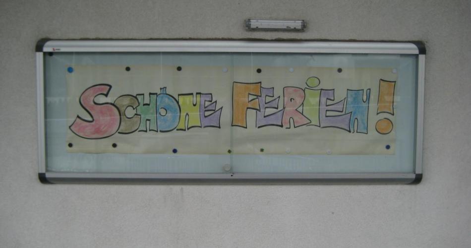 Plakat "schöne Ferien" im Schaukasten der Schule