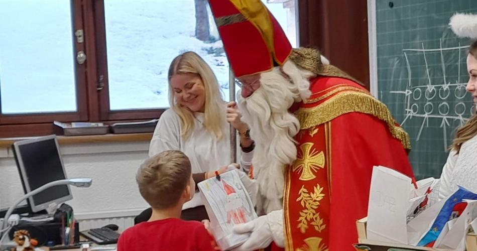 Nikolaus übergibt ein Geschenk an ein autistisches Kind