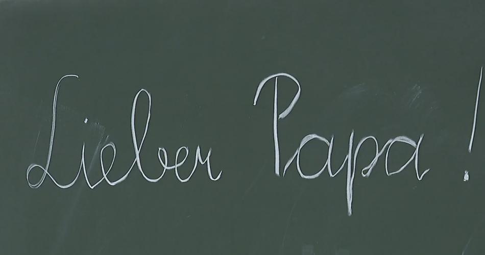 Text auf der Tafel: Lieber Papa!