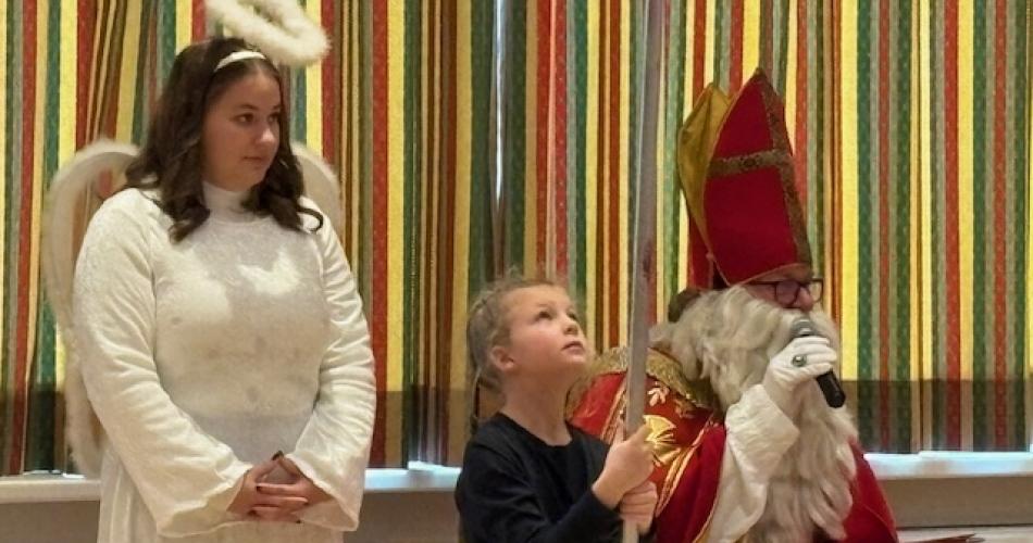 Nikolaus und Engel und ein Mädchen hält den Stab