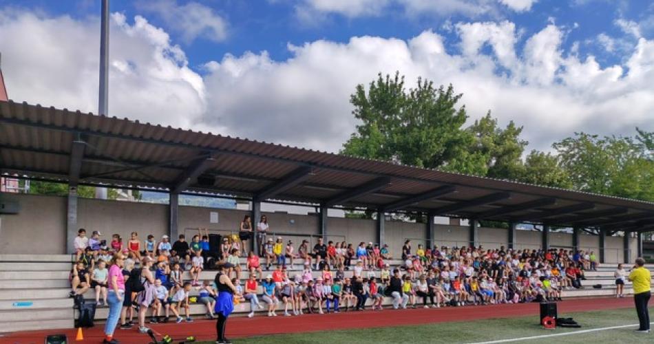 Blick auf die Besucherränge des Sportplatzes, wo alle Kinder sitzen