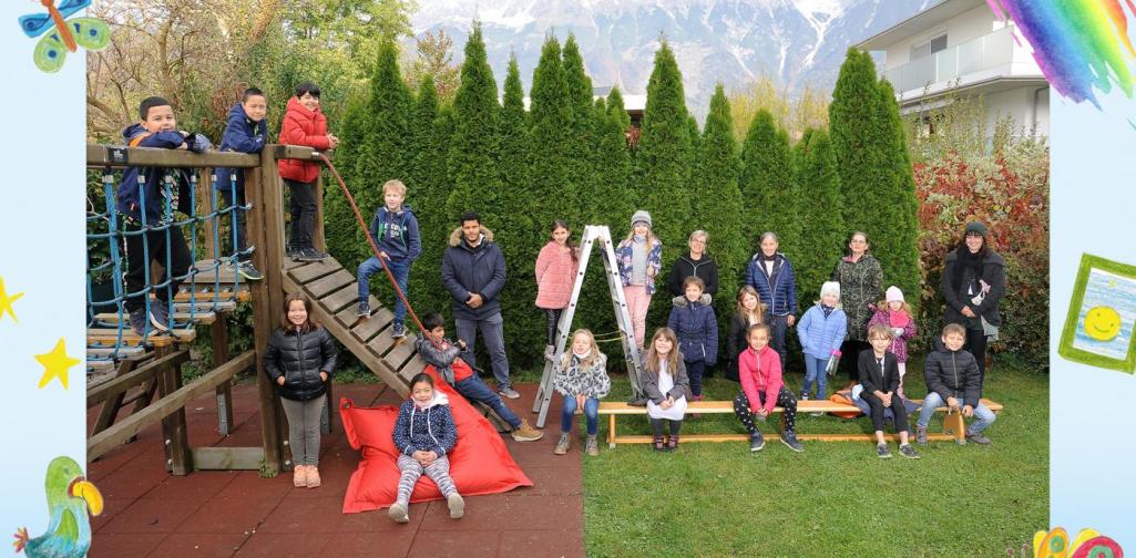 2a-Kinder sitzen im Garten und am Klettergerüst